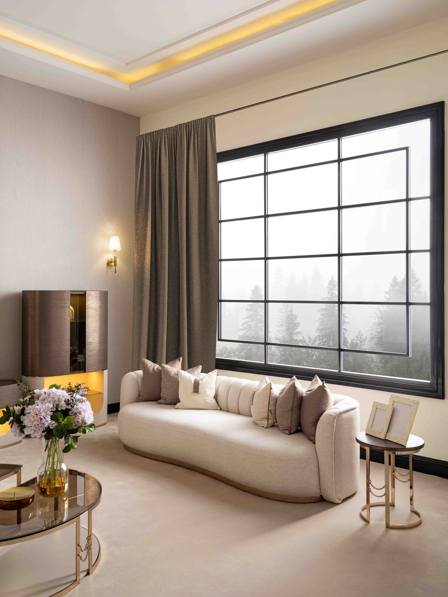 Side view of the Calista 4-seater sofa upholstered in a gray fabric, highlighting the integrated golden metal side table for modern living room furniture.