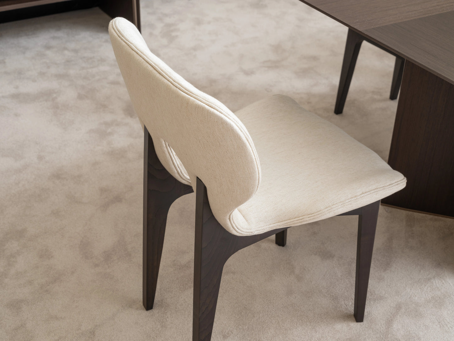 Detailed view of cream upholstered Moka dining chair with wooden frame