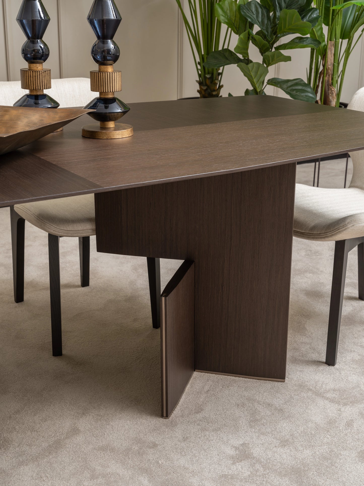 Detailed view of Moka dining table leg design and cream upholstered chair