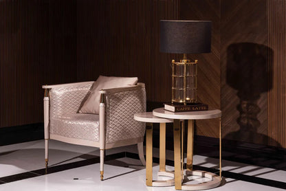 Luxury modern Braga armchair with champagne quilted upholstery and gold-tipped legs in a dark wood lounge