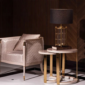 Luxury modern Braga armchair with champagne quilted upholstery and gold-tipped legs in a dark wood lounge