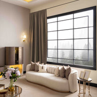 Side view of the Calista 4-seater sofa upholstered in a  gray fabric, highlighting the integrated golden metal side table for modern living room furniture.