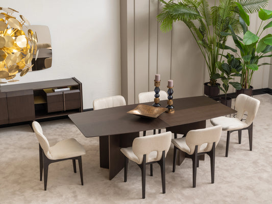 Moka dining room set with six cream upholstered chairs, dark wood table, gold chandelier, and large plants