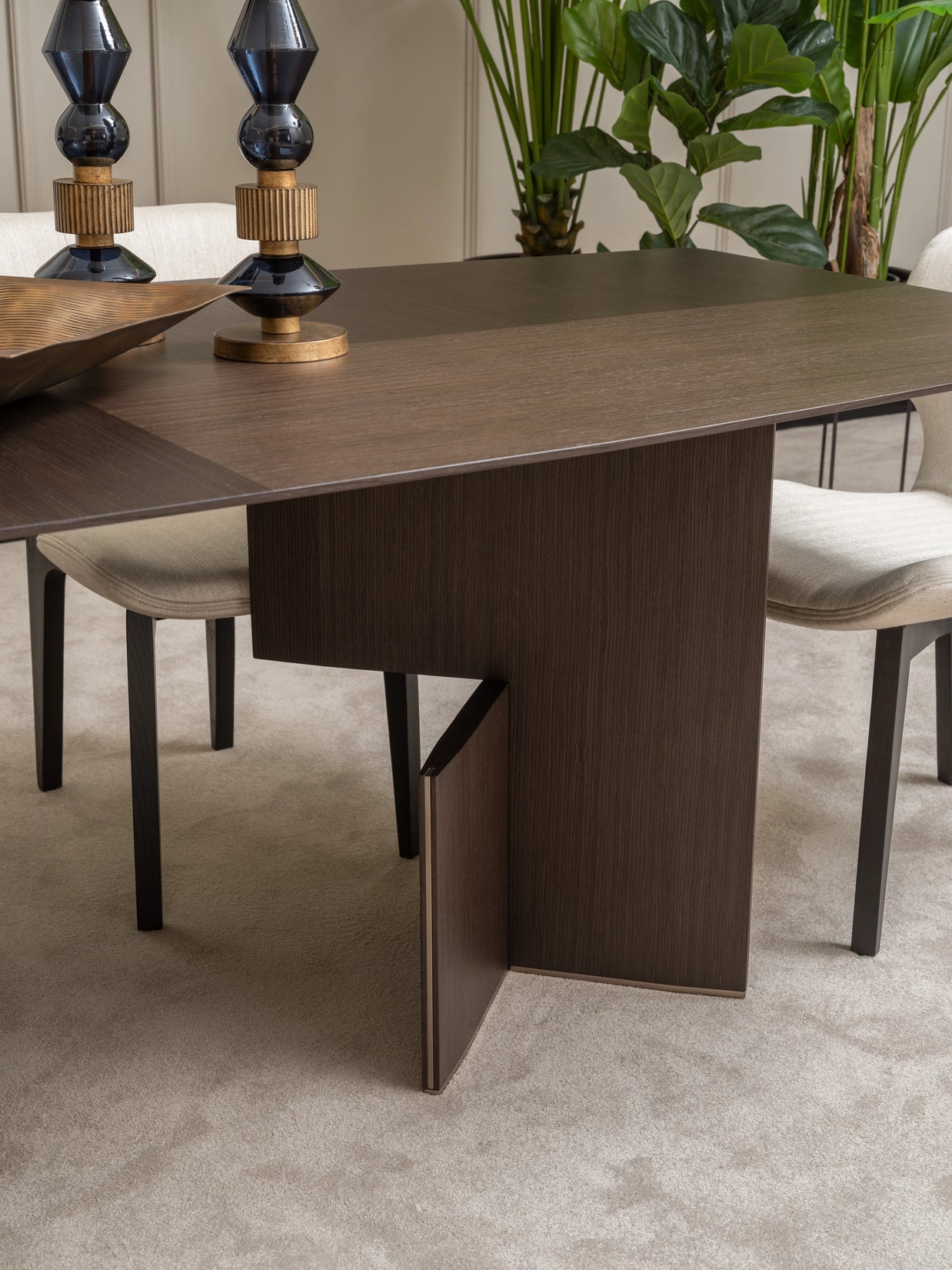 Detailed view of Moka dining table leg design and cream upholstered chair