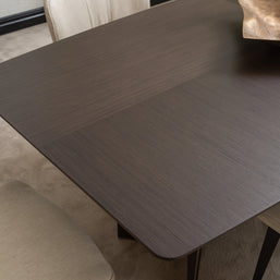 Close-up of Moka dining table surface in dark wood veneer with gold centrepiece