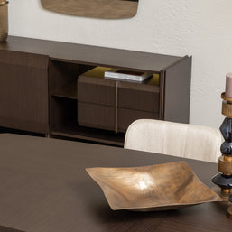 Close-up of Moka sideboard and gold decor beside contemporary dining table